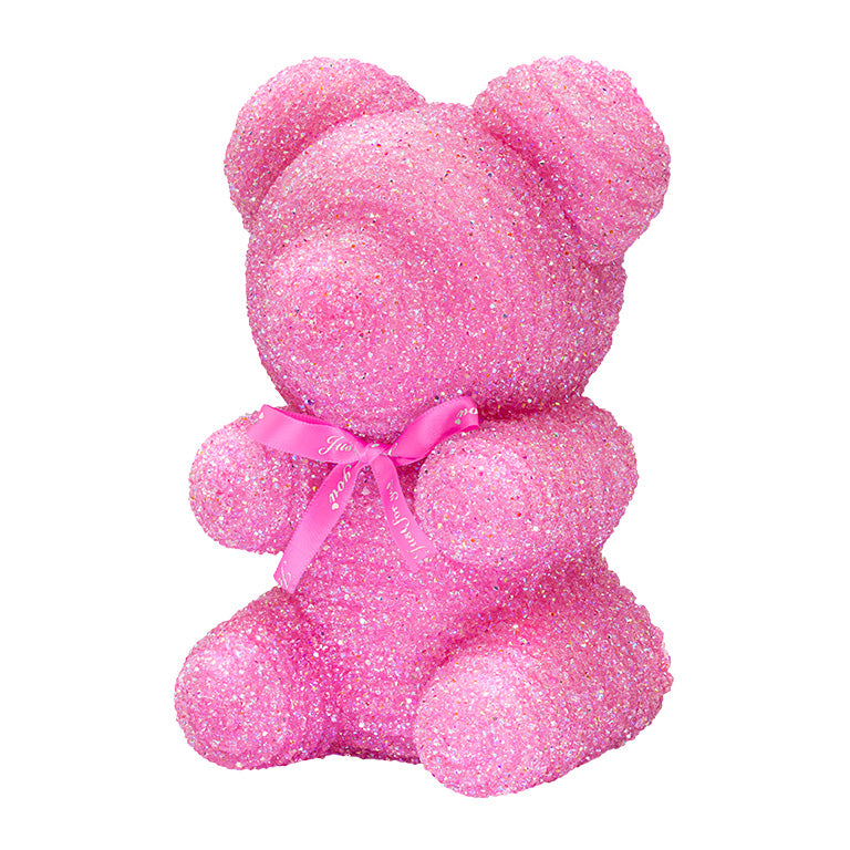 A decorative bear with pink plastic glitter covered around the styrofoam bear.