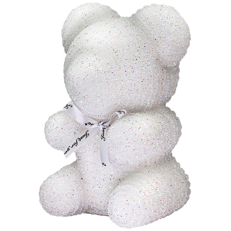 A decorative bear with white plastic glitter covered around the styrofoam bear.