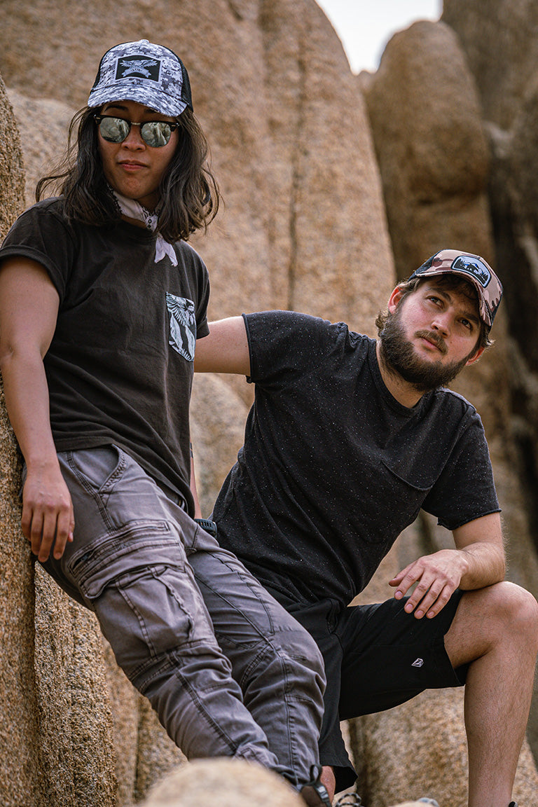 A photoshoot of two models wear summer hats while hiking in the mountains