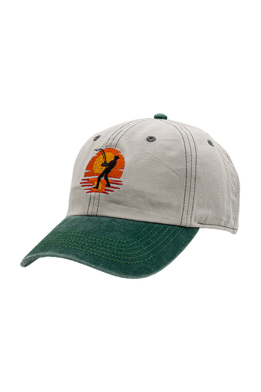 Side view of base baseball cap. Green color visor with grayish cap. With an embroidered design of a fishermen in front of sunset