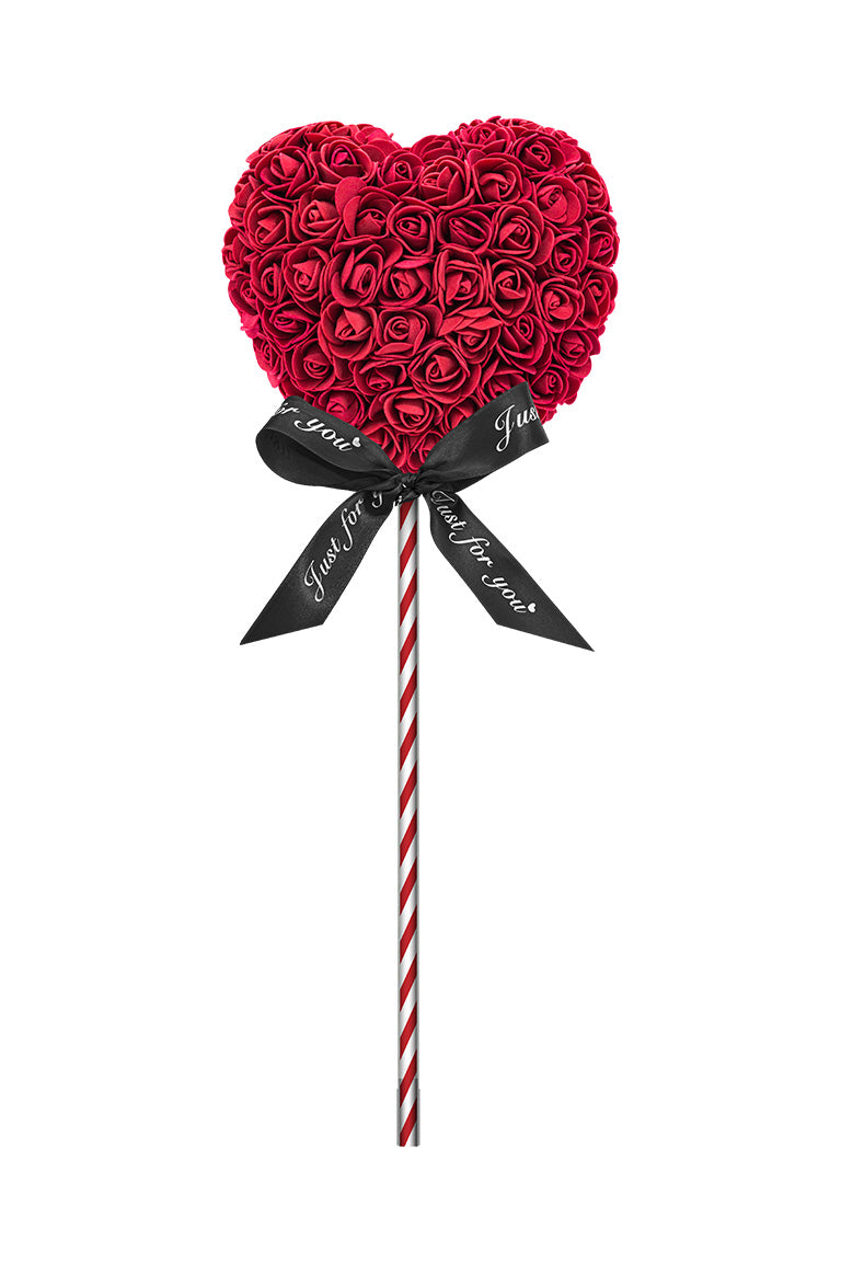 A heart shape lollipop looking decoration. Heart is burgundy cover in foam flowers. Attached with a red and white swirl stick with a black bow.