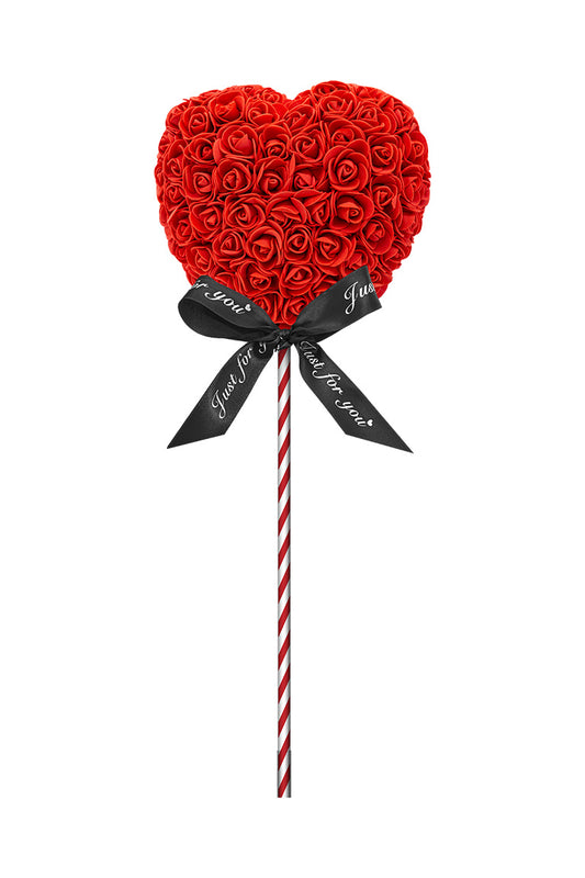 A heart shape lollipop looking decoration. Heart is red cover in foam flowers. Attached with a red and white swirl stick with a black bow.