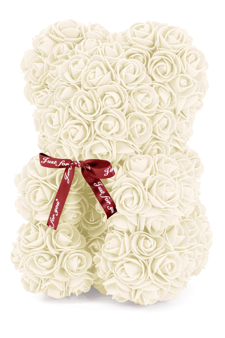 A bear shape decorative piece covered in cream foam flowers. With a black bow ribbon around underneath the head.