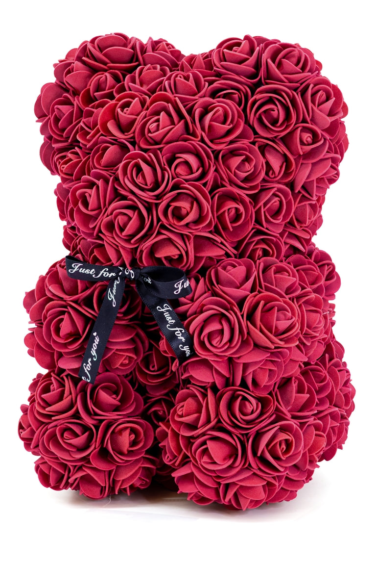 A bear shape decorative piece covered in burgundy foam flowers. With a black bow ribbon around underneath the head.