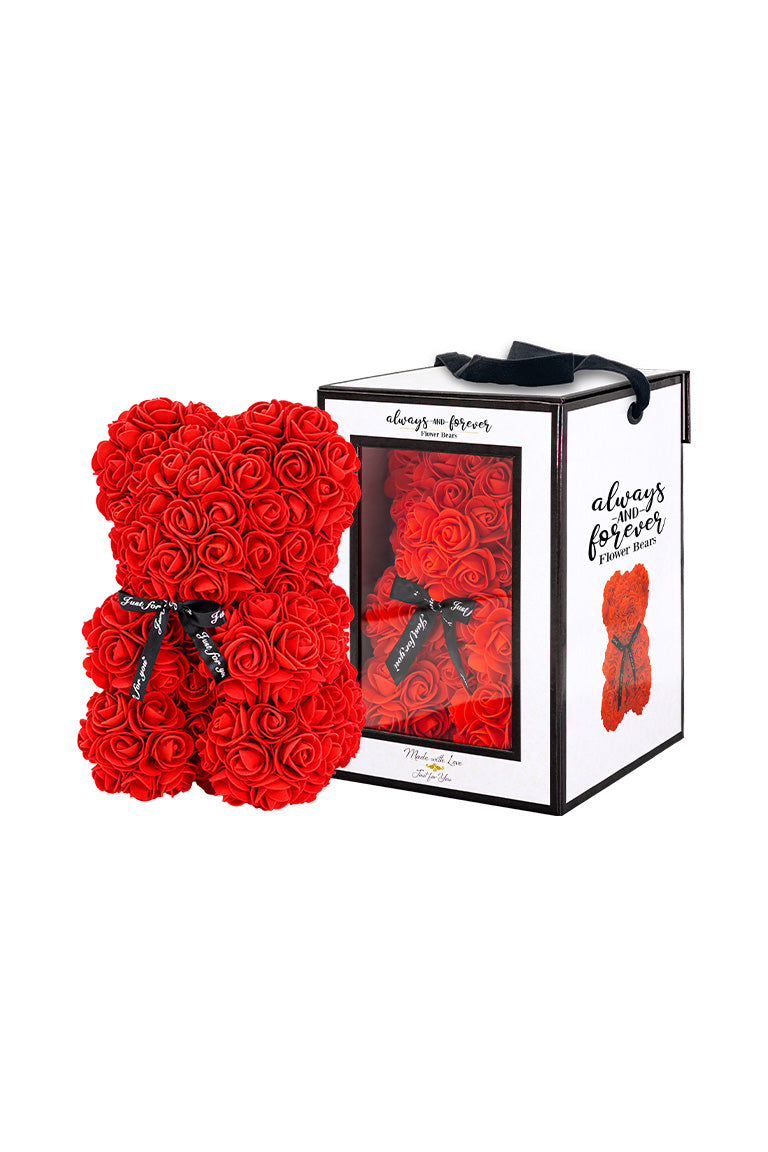 A bear shape decorative piece covered in red color foam flowers. With a black bow ribbon around underneath the head. Next to a white packaging box