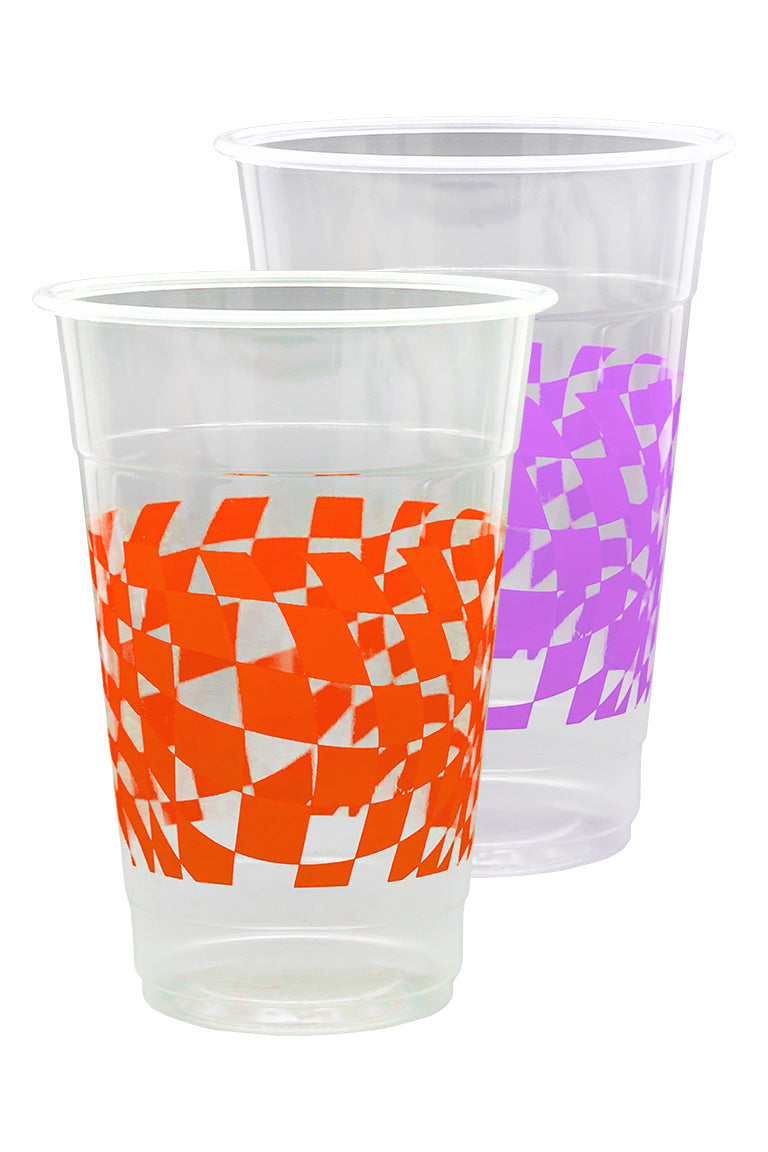 Close up of beer pong cups. 1 clear plastic cup with a purple checkered design and the other cup with a orange checkered design.