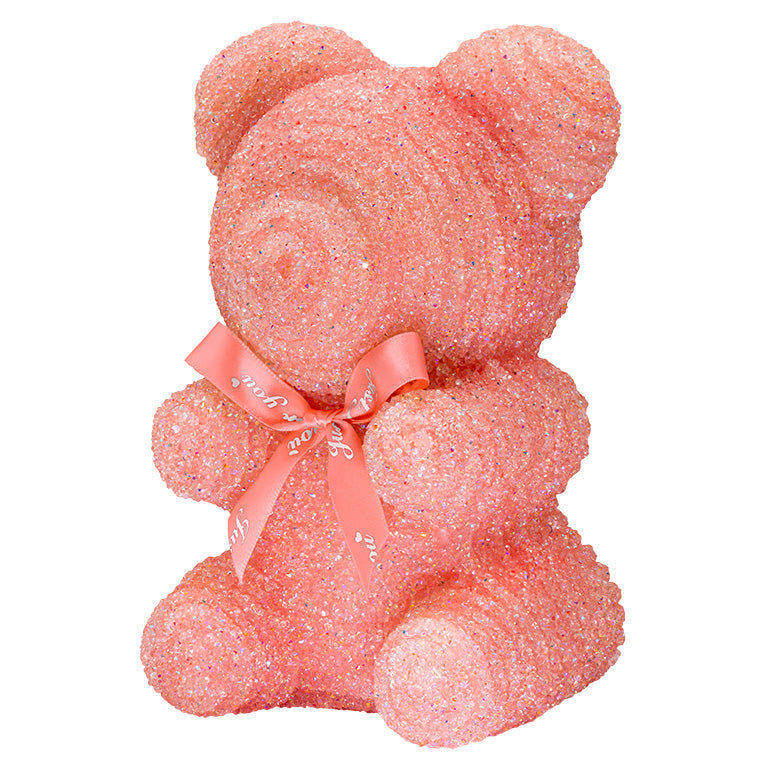 A decorative bear with light pink plastic glitter covered around the styrofoam bear. 
