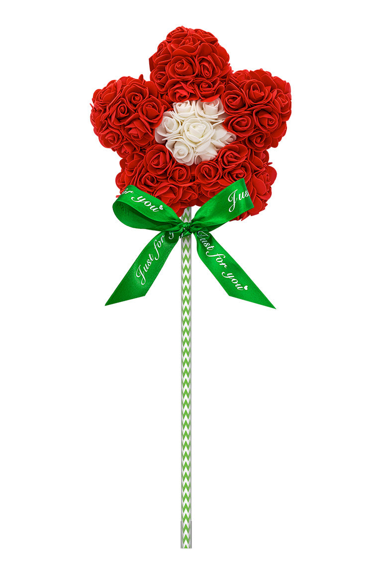 A flower shape lollipop looking decoration. Flower is red with a white center. Attached with a green and white swirl stick with a green bow.